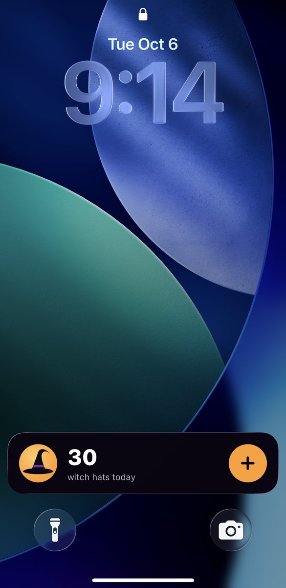 A locked iPhone with the WitchCatcher card at the bottom of the Lock Screen: a witch hat, 30 witch hats today, and an orange + button